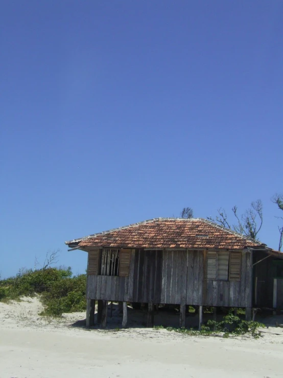 there is a old house sitting on the beach