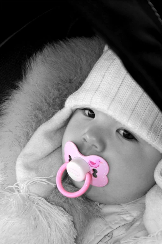 a baby is wearing a hat and pacifier in the mouth