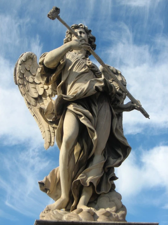 an angel statue is holding an instrument in its hand