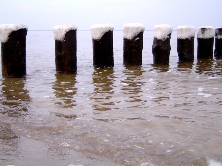 water is reflected on the concrete posts in the lake