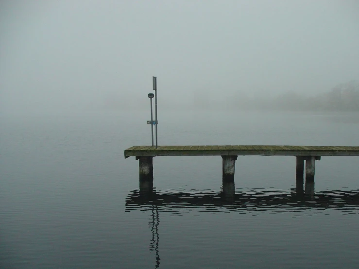 a dock is surrounded by fog and water