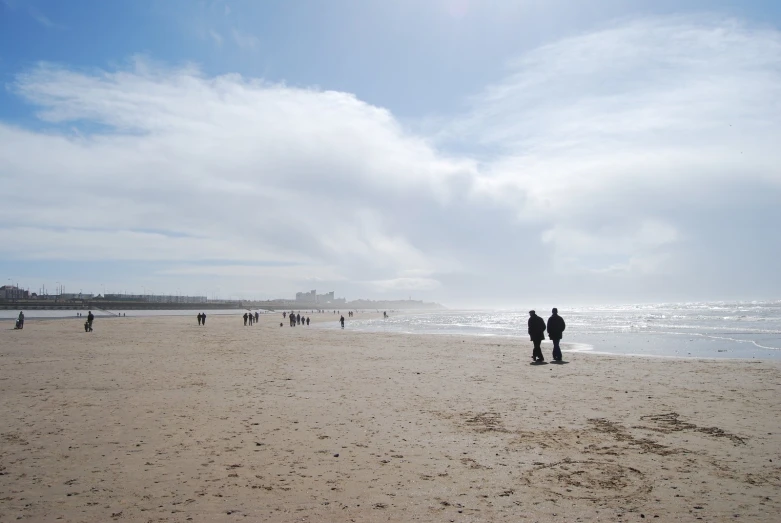 a group of people standing on top of a sandy beach