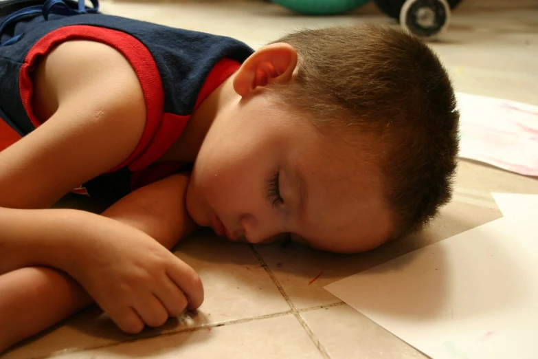 boy with his head down sleeping on the floor