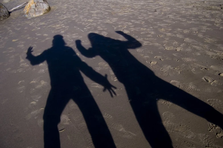 two people standing next to each other in the sand