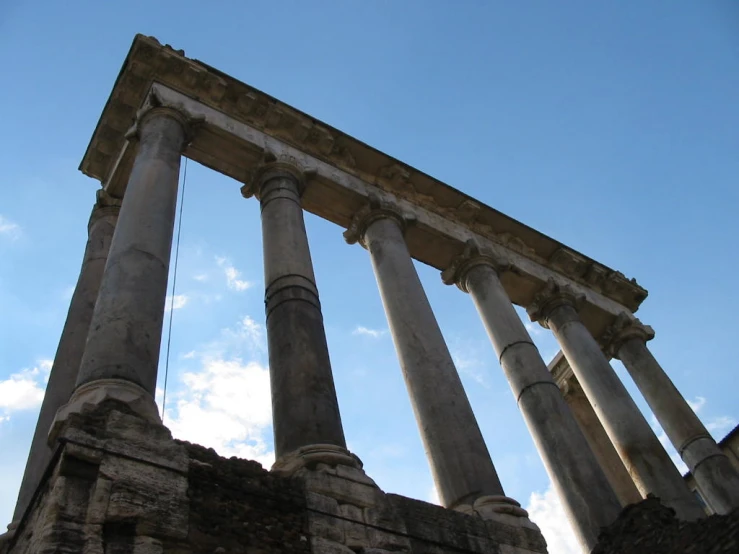 an old ruin with several pillars against a clear blue sky