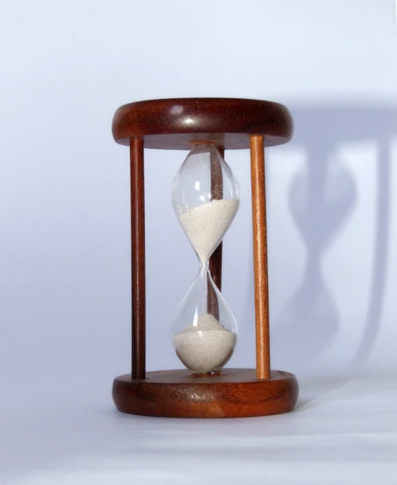 an hourglass sitting on a wooden stand