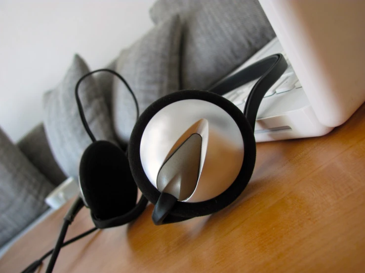 a wooden table topped with a computer and headphones