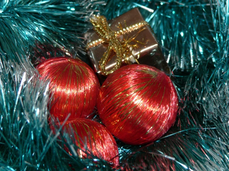 a red christmas ornament on the back of two balls in a christmas tree