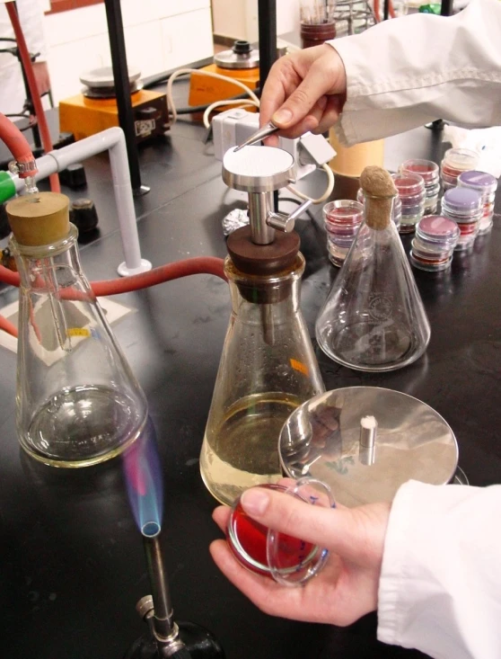 a scientist working with a beakle filled with liquid and sample samples