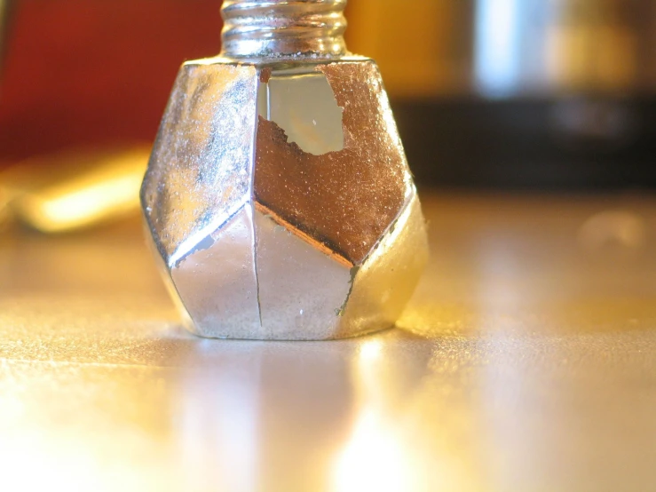 silver liquid bottle containing white, brown, and silver flecks