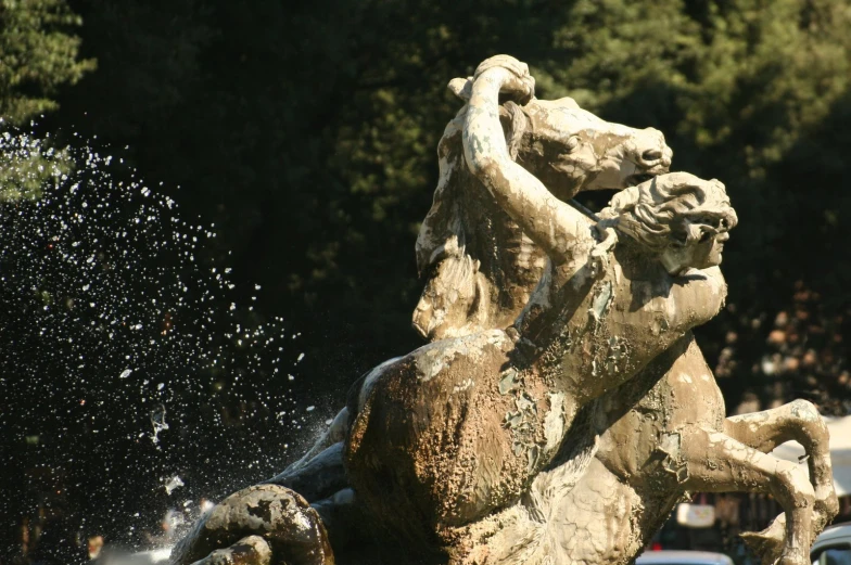 a fountain is splashing water at some statues