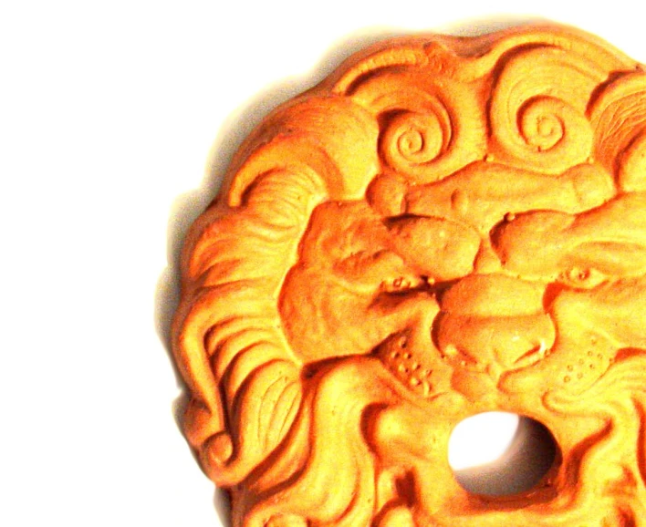 an old carved wooden circular decoration of fooons