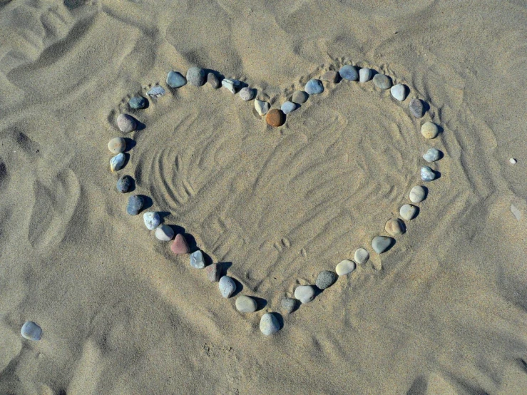 a heart made out of rocks on a beach