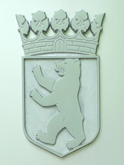 a wall mounted emblem depicting a bear with a crown