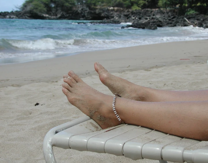 a mans bare feet as he relaxes on the beach