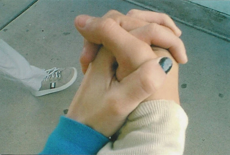 a couple holding hands with tattoos on their fingers