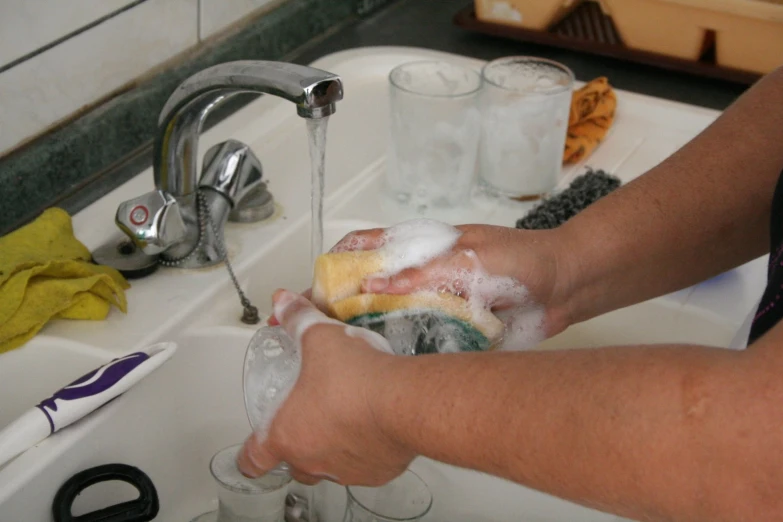 a person washing their hands on the sink