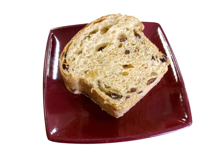 bread with raisins sits on a red plate