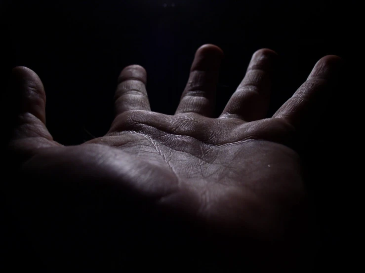 a hand holding an object in the dark