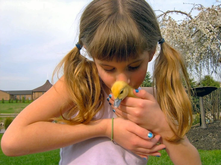 a little girl in white shirt and some grass