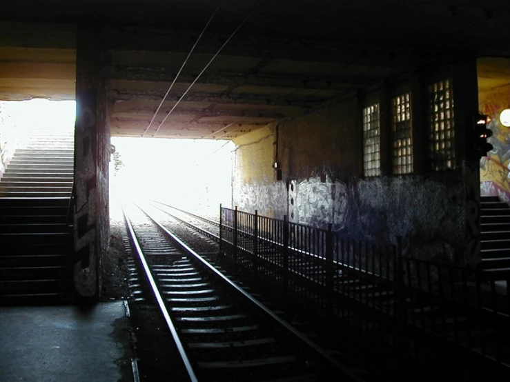 a lone train on the tracks near some railings