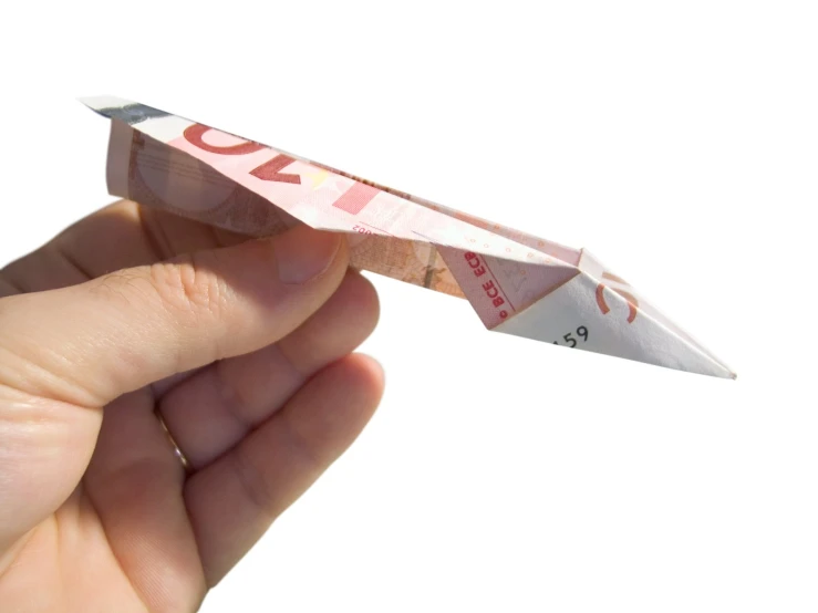 a person is holding an origami toy that looks like an airplane