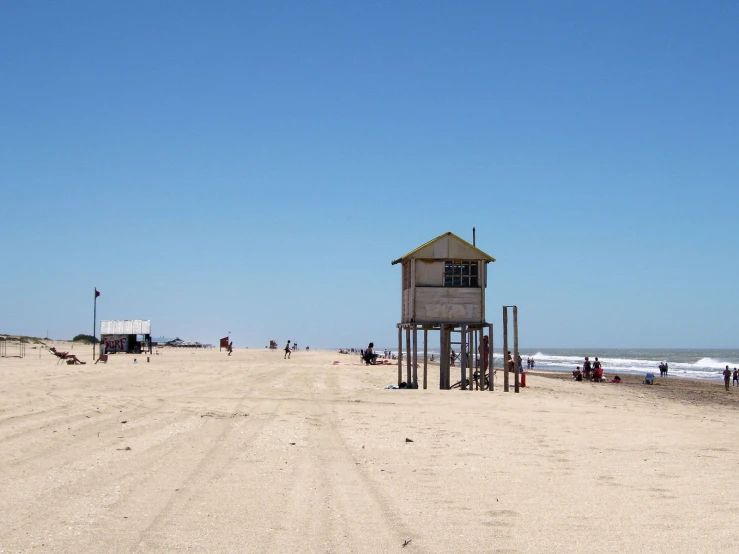 a building with people standing on the beach in front