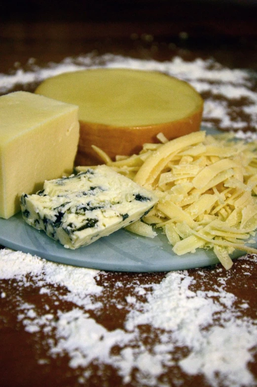 cheese and parmesan cheese on a plate surrounded by snow