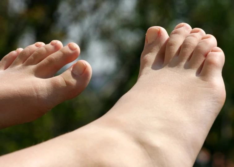 a bare foot sitting next to a forest