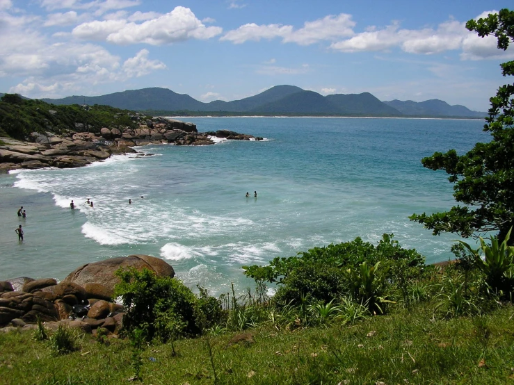 there is a body of water on a beach with many people