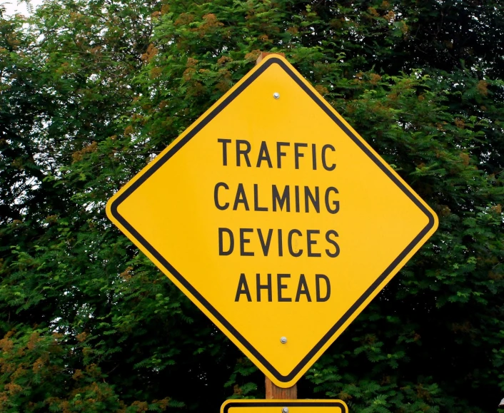 a traffic sign on a pole stating it is cautioning people to keep moving