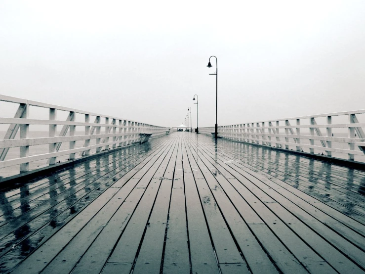 an empty wooden pier in the rain