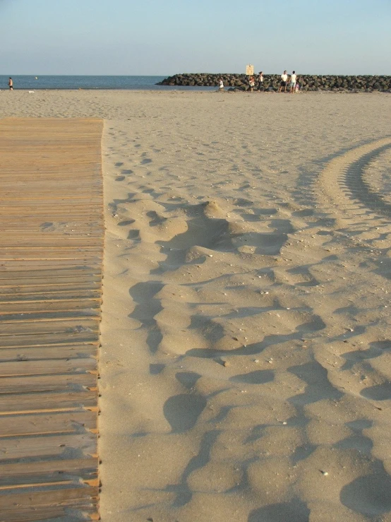 a sandy beach with waves going in the sand