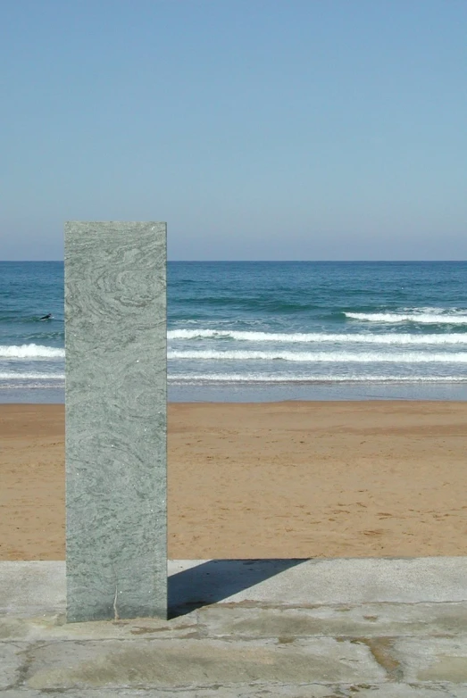 a concrete block on a beach with the ocean in the background