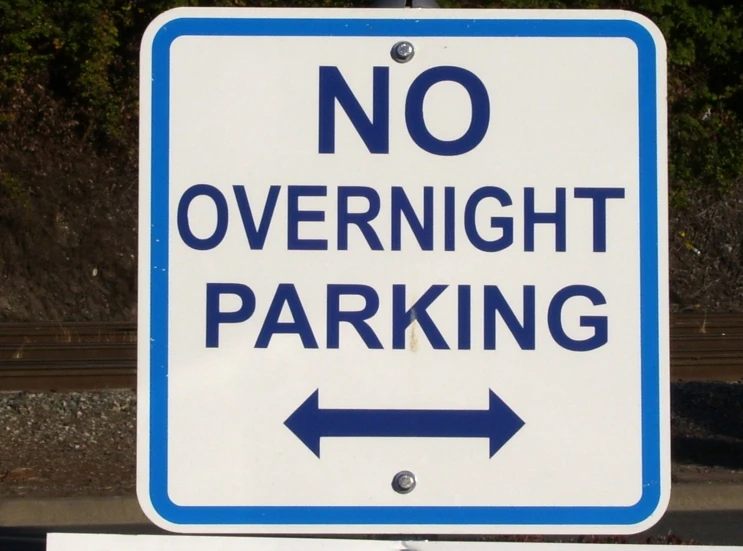 a sign that says no overnight parking is in blue and white