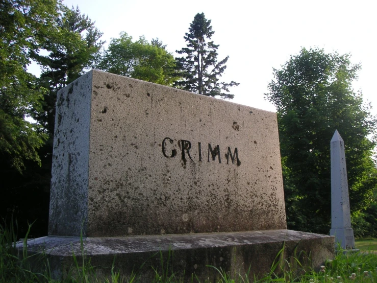 an old grave sits in the middle of the grass