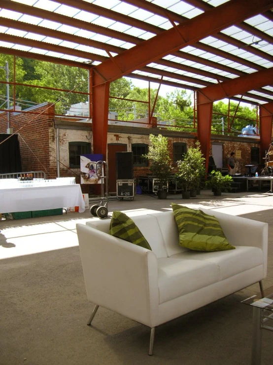 the inside of an outdoor lounge with a lot of furniture and plants