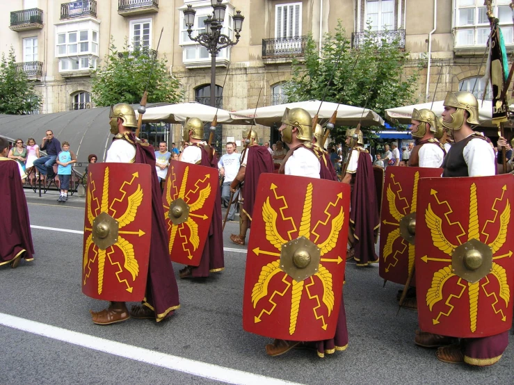 some people are walking on a street with some helmets