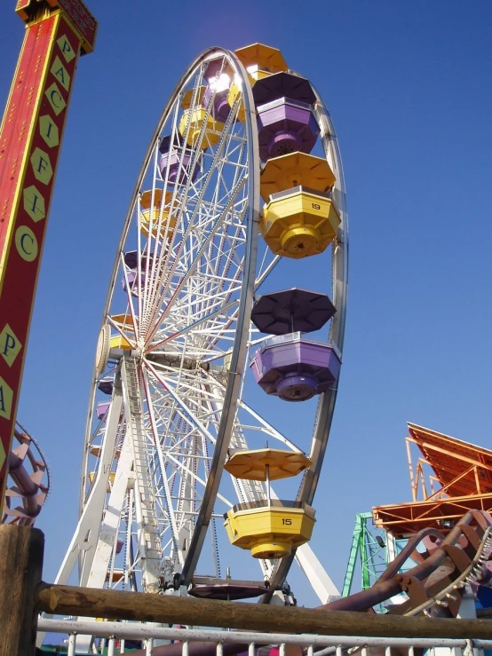 a colorful ferris wheel in the sky next to a boardwalk