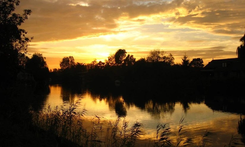 sunset at the edge of lake with boats out front