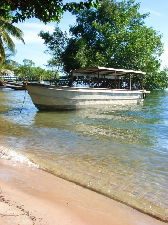 small boat at edge of calm body of water