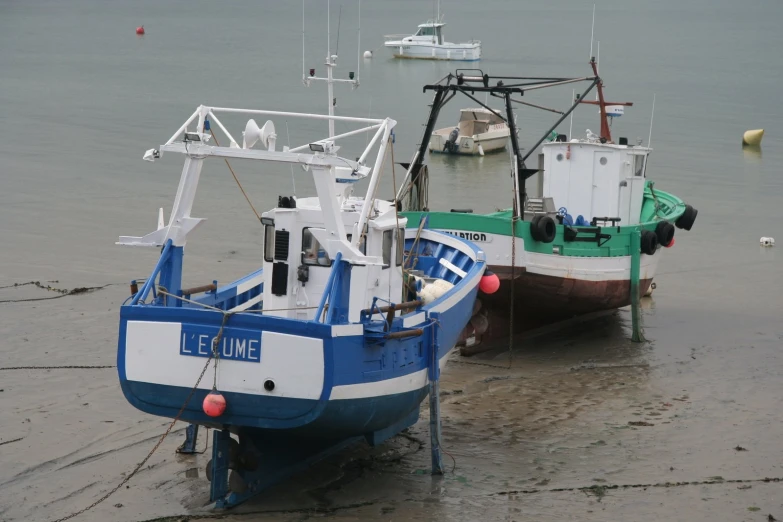 two boats sitting next to each other on the beach