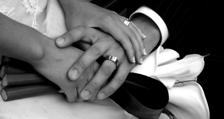 a newlywed couple hold each other by their hands