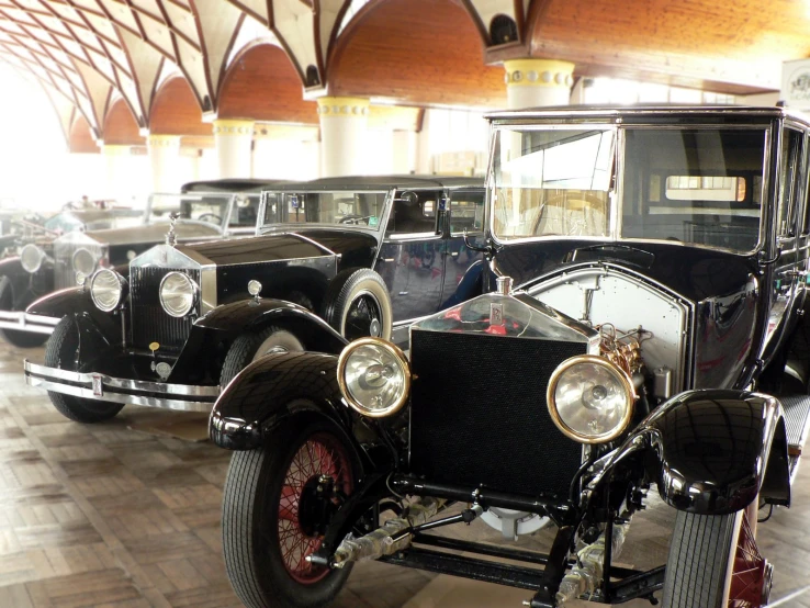 several old - fashioned cars sit on display in a museum