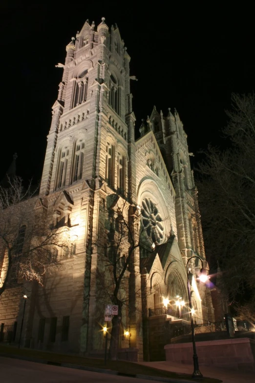 an old building is shown lit up with street lamps