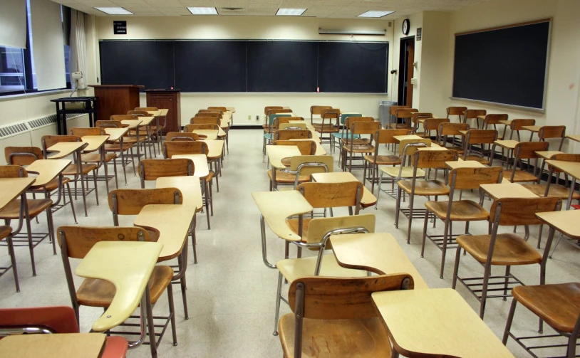 empty classroom with desks and an chalkboard