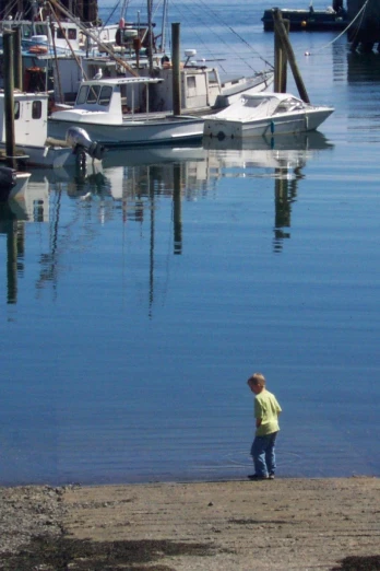 a little boy looking at boats and docked ships