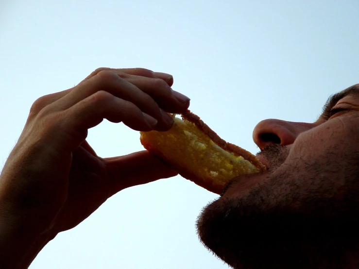 a man eating a donut in the daytime