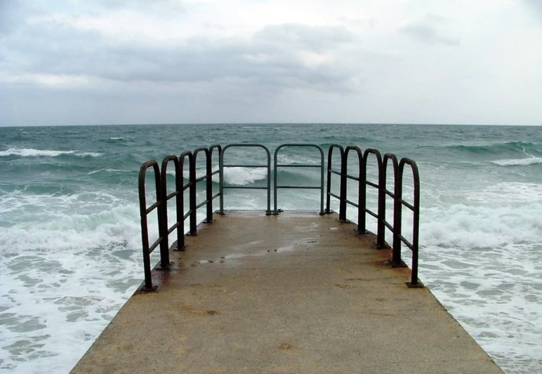 the end of a pier sticking out into the ocean