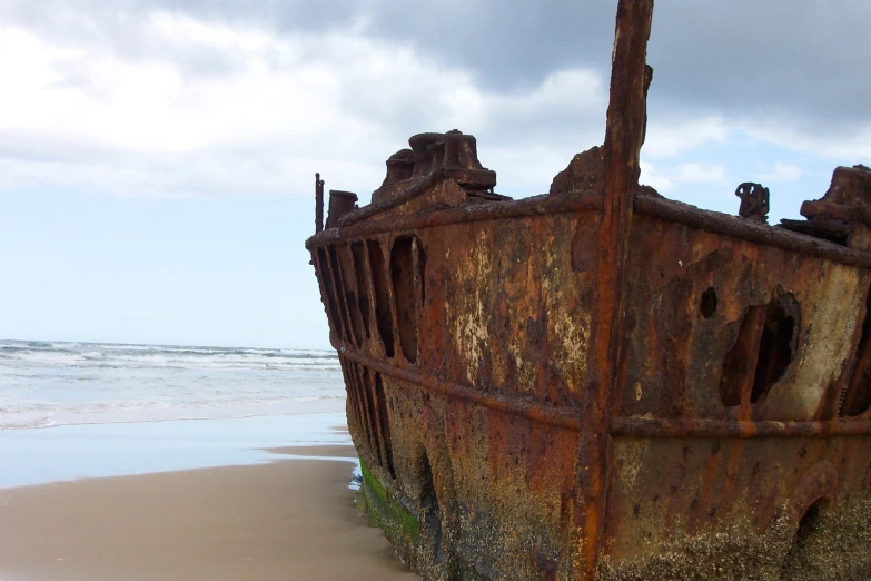 an old rusted out ship sitting in the ocean